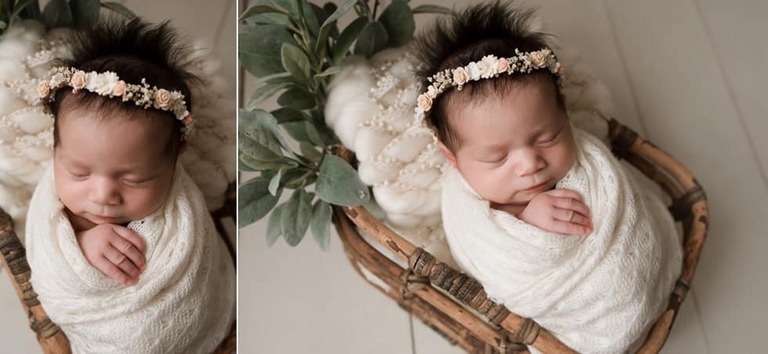 Baby girl wrapped in textured cloth with floral headband and white wood floors.