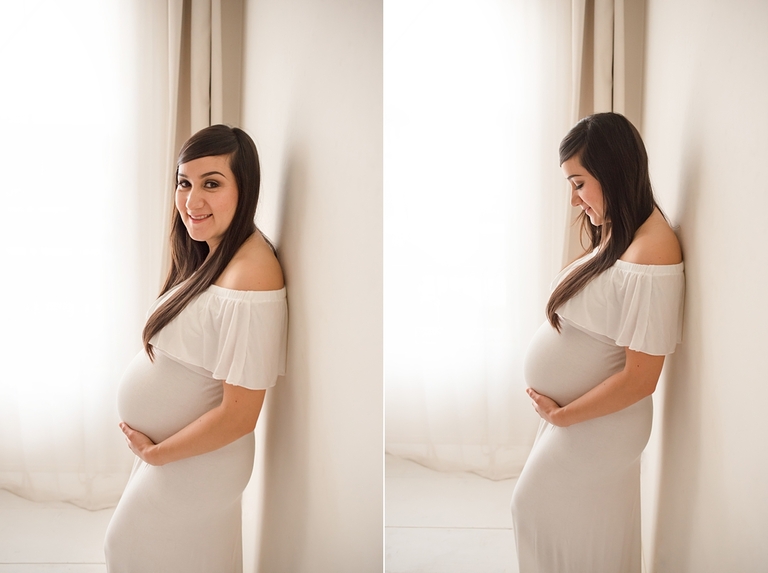 Maternity pose in white gown backlit with large soft light window. 