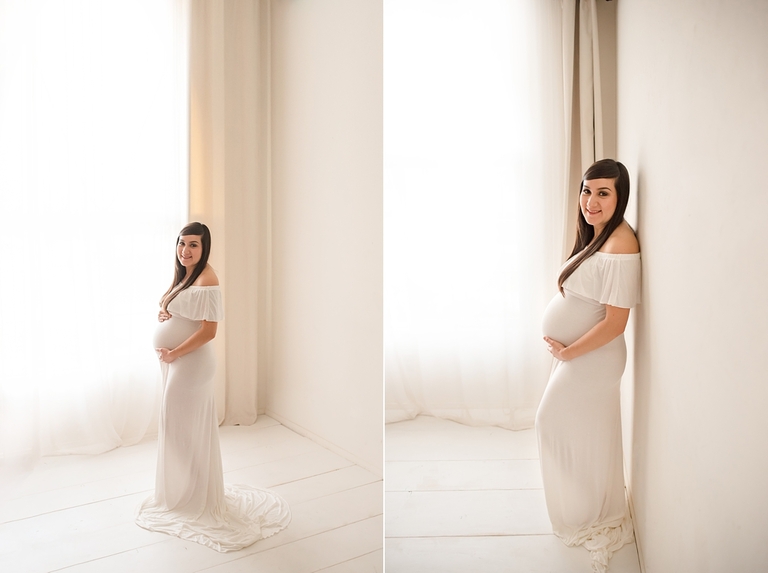 Maternity pose in white gown backlit with large soft light window. 