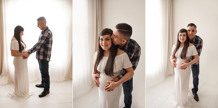 Maternity pose with dad in white gown backlit with large soft light window. 