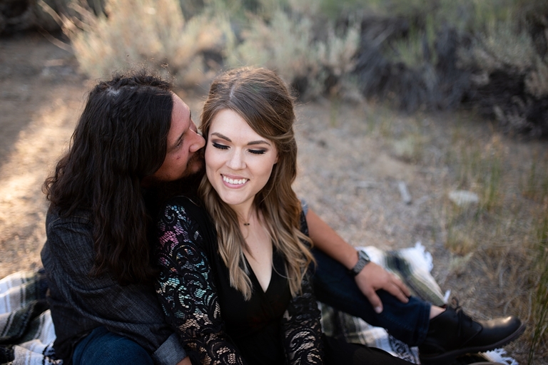 Couple in front of forest embracing for engagement photos